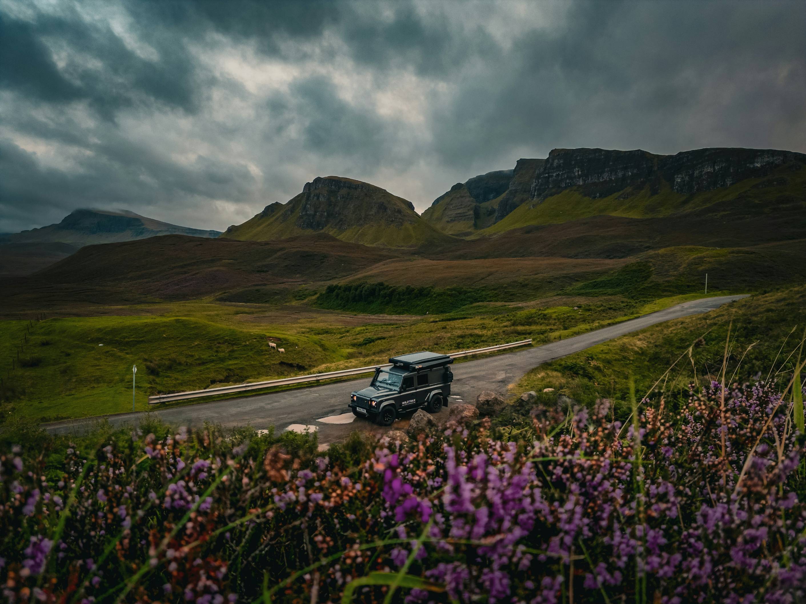 a truck driving down a road in the mountains