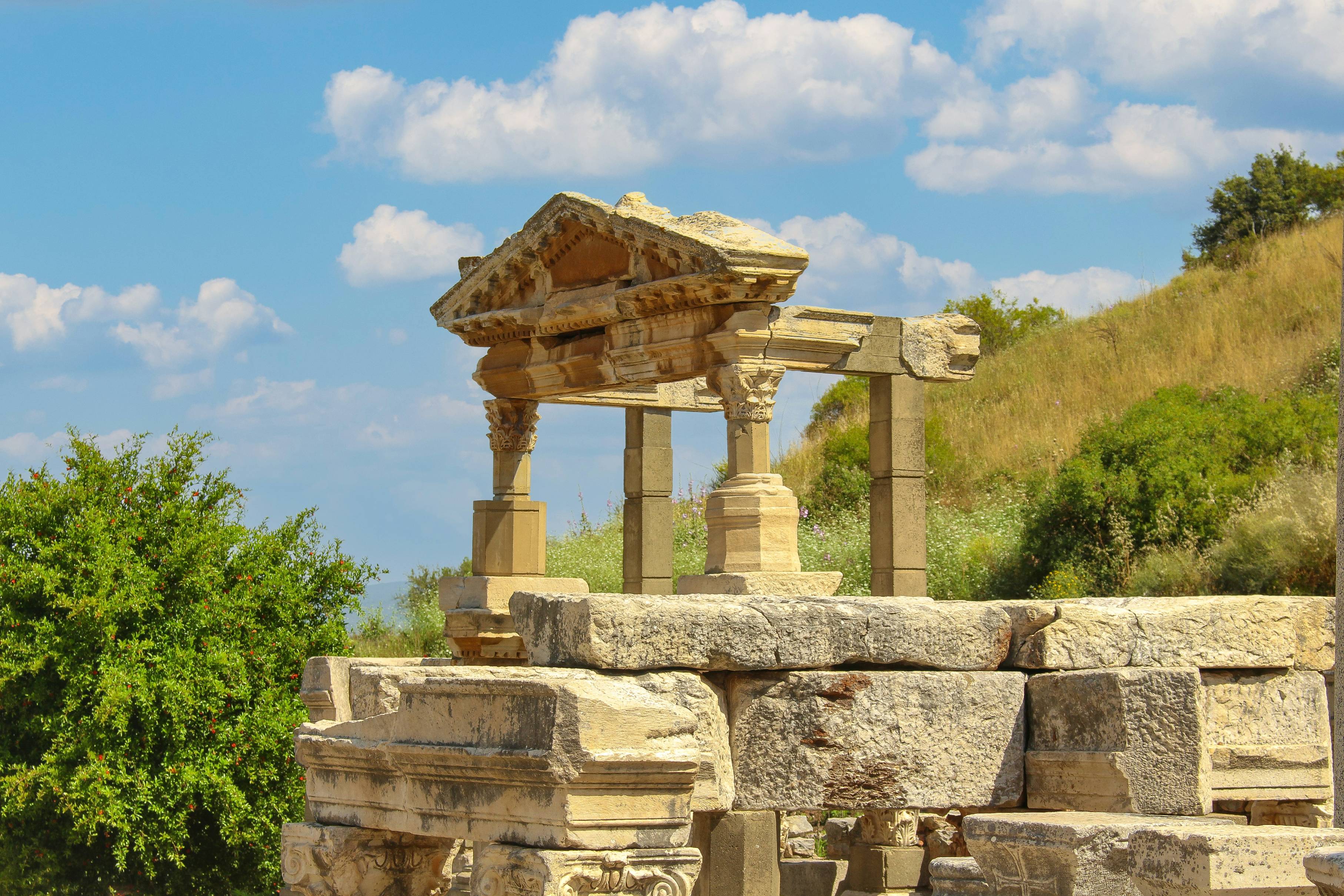 a stone structure sitting on top of a lush green hillside