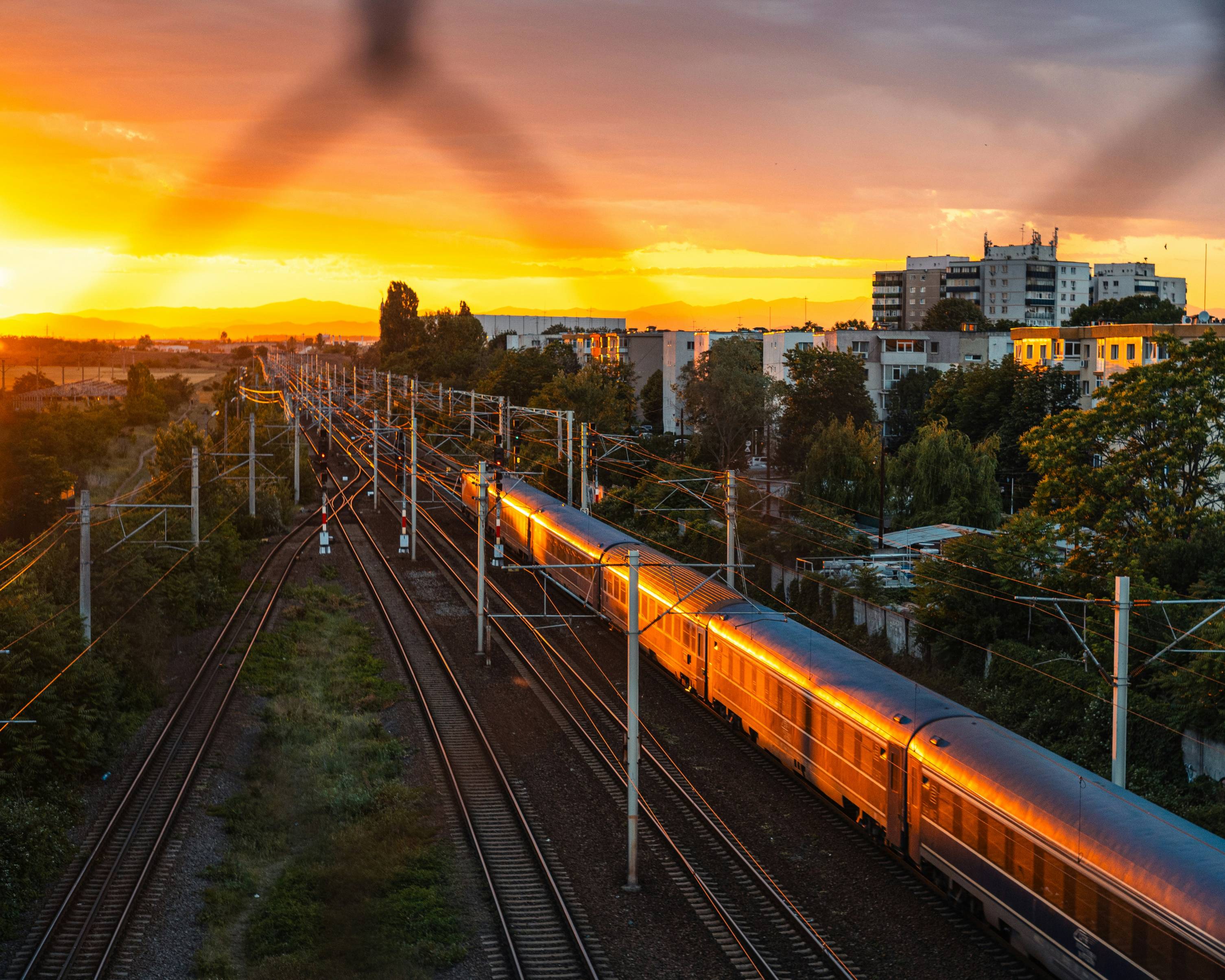 a train traveling down train tracks near a city