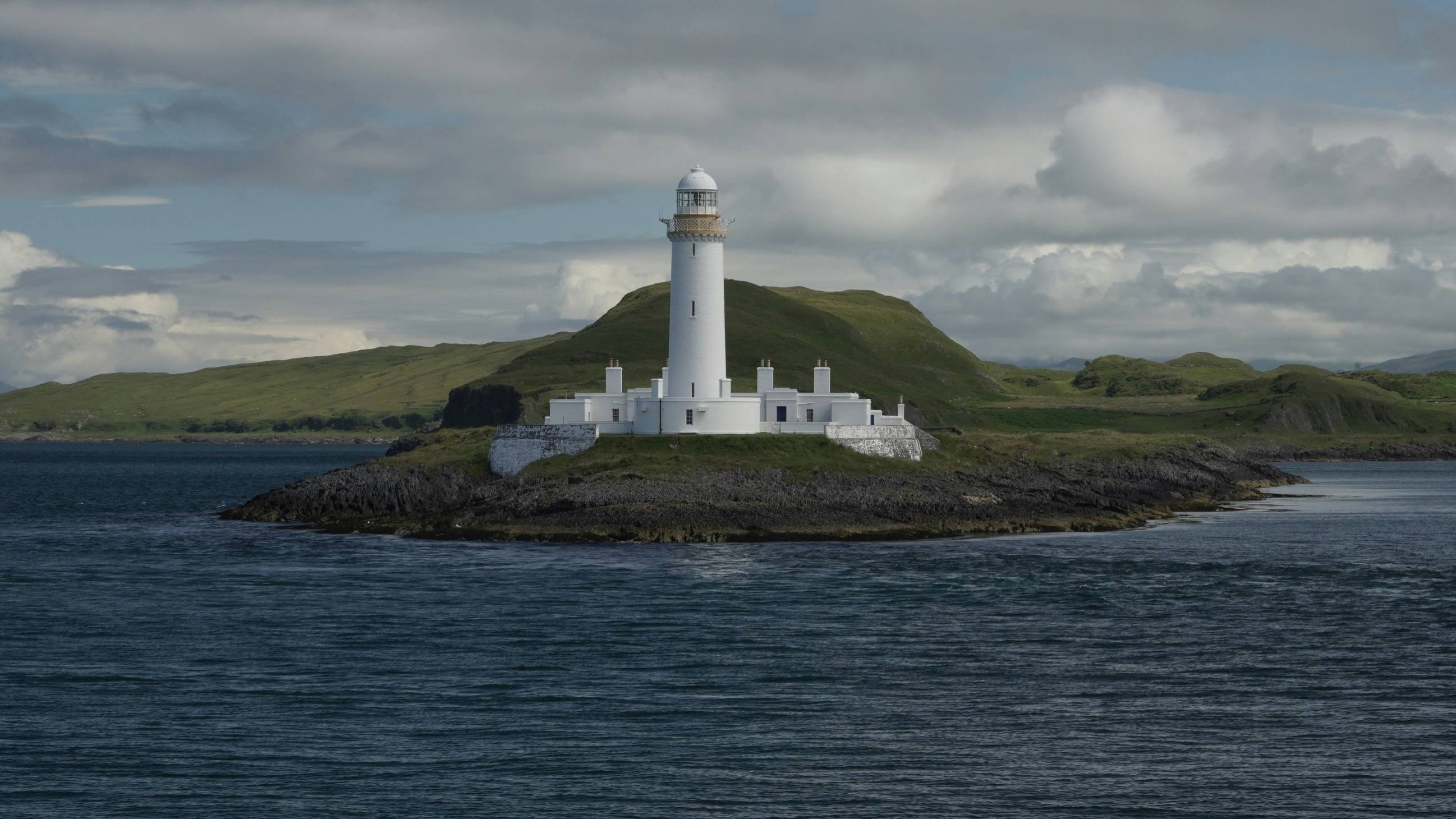 A lighthouse on a small island in the middle of the ocean