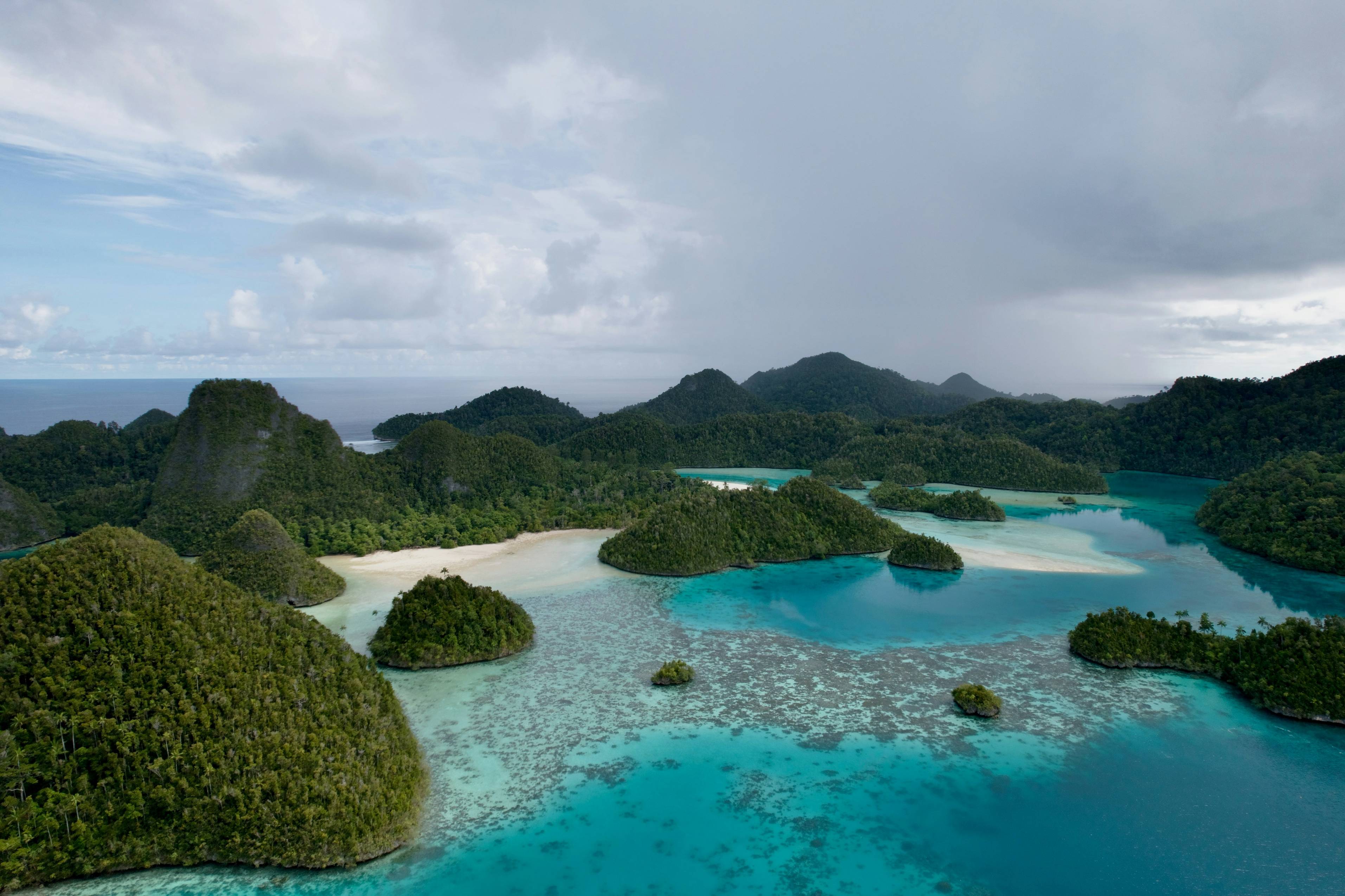 Islands dot a turquoise sea beneath cloudy skies.
