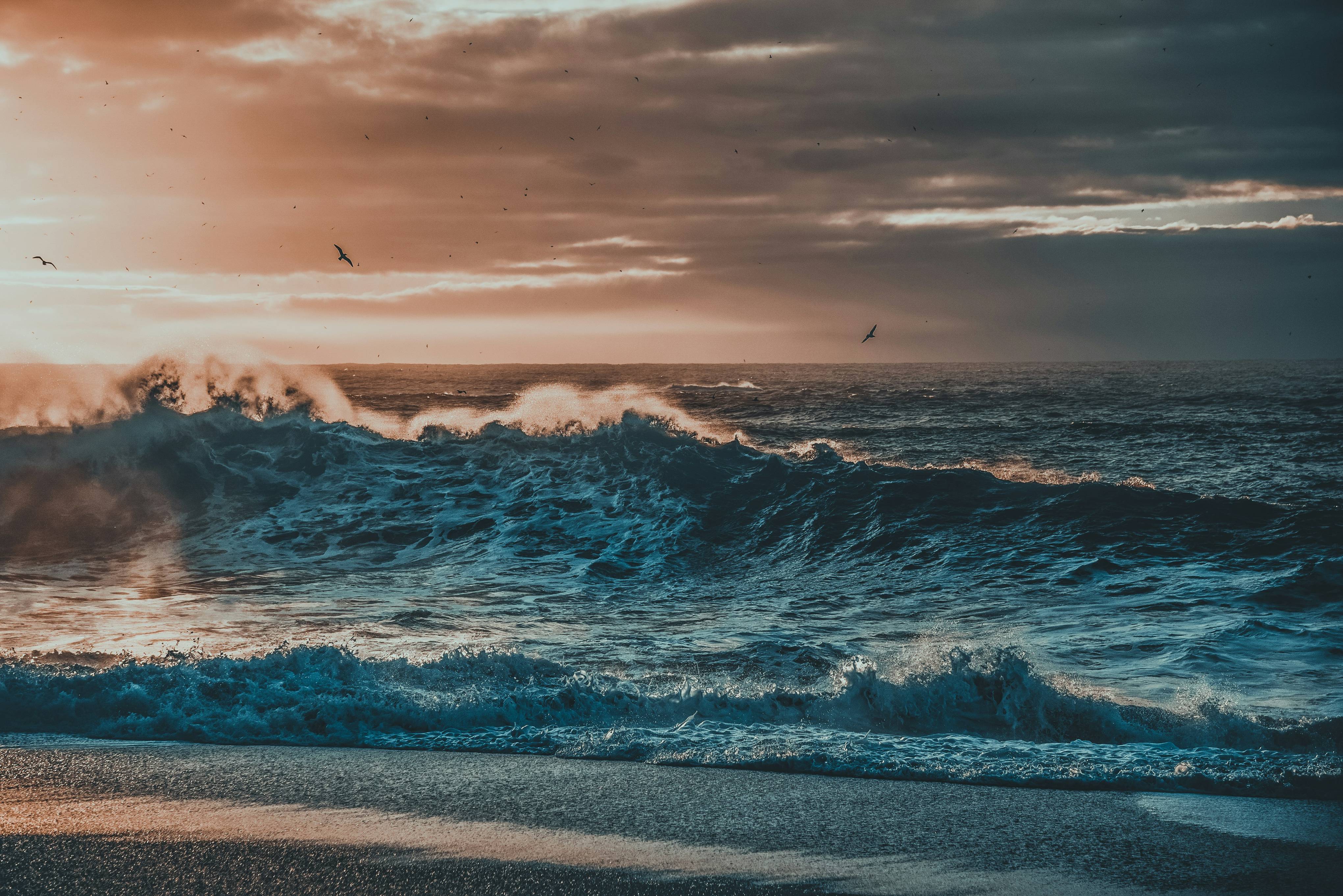 the sun is setting over the ocean waves