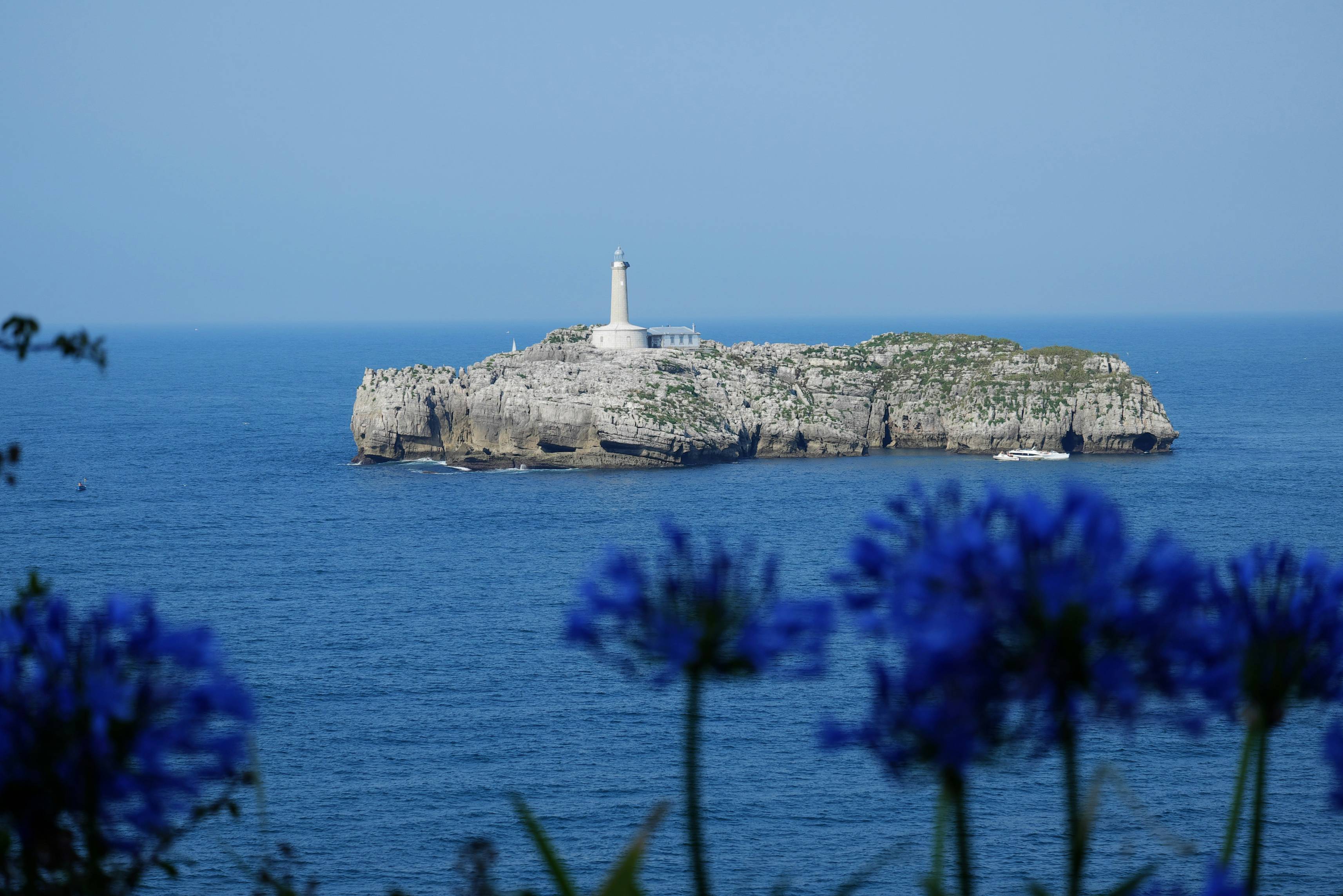 white lighthouse on top of the hill